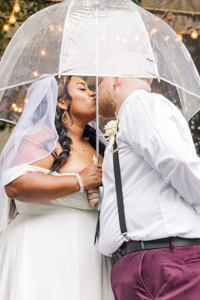 The Corley Mill House wedding couple kissing under umbrella