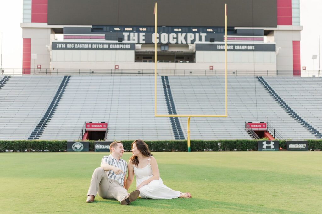 Couple sitting on the field of Williams-Brice Stadium