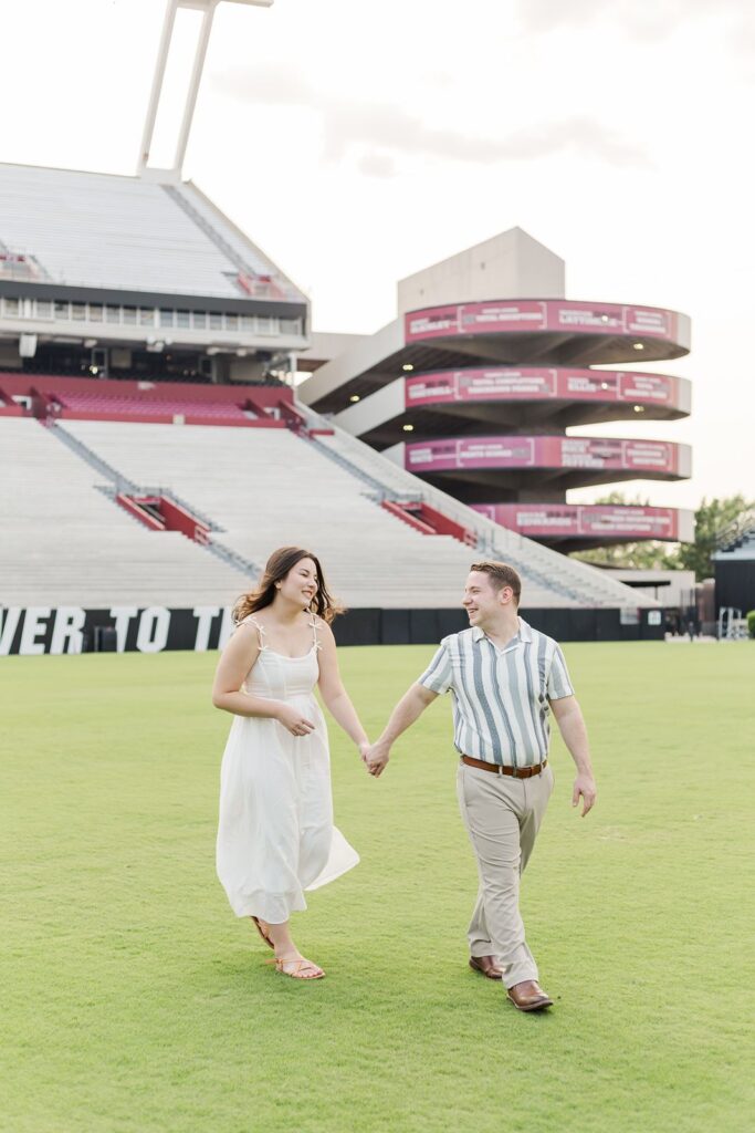 Couple holding hands on the field of Williams-Brice Stadium